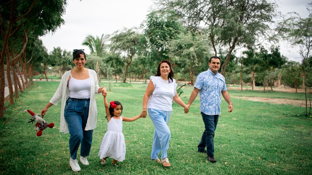 a group of people walking across a lush green field