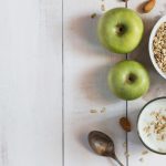 Glass of yoghurt, cereal and apples