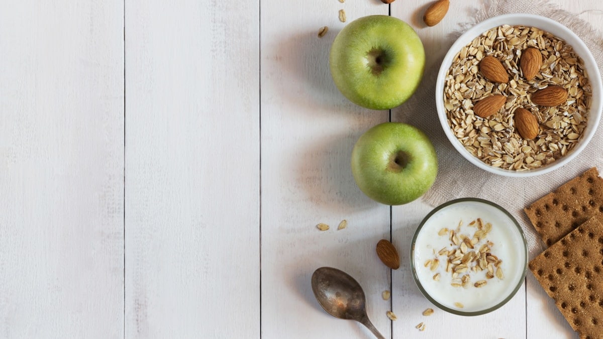 Glass of yoghurt, cereal and apples